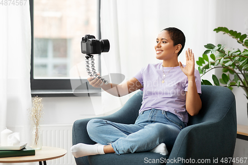 Image of female blogger with camera video blogging at home