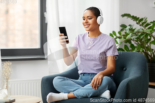 Image of woman with smartphone listening to music at home