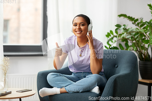 Image of woman in headphones listening to music at home