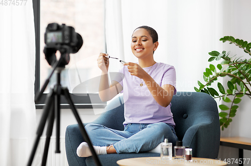 Image of female beauty blogger with camera and mascara