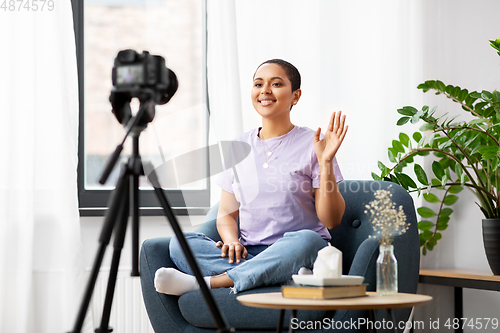 Image of female blogger with camera video blogging at home