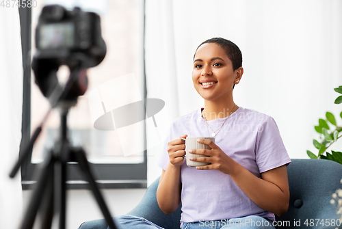 Image of female blogger with camera and coffee at home