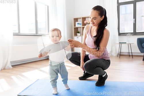 Image of happy mother with little baby at home