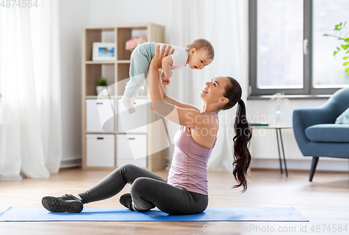 Image of happy mother with little baby exercising at home
