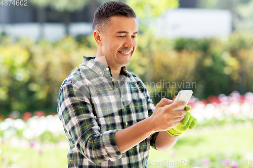 Image of happy man with smartphone at summer garden