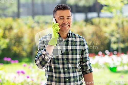 Image of happy man calling on smartphone at summer garden