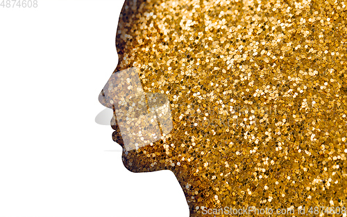 Image of silhouette of woman face on golden glitters