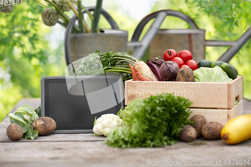 Image of close up of vegetables with tablet pc on farm