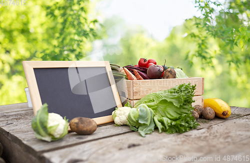 Image of close up of vegetables with chalkboard on farm