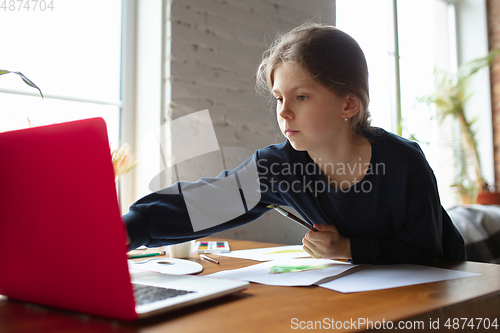 Image of Girl drawing with paints and pencils at home, watching teacher\'s tutorial on laptop. Digitalization, remote education