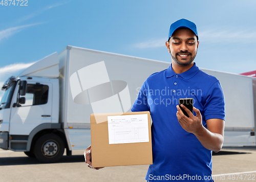 Image of indian delivery man with smartphone and parcel box