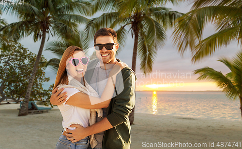 Image of happy friends walking along summer beach