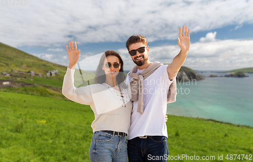 Image of happy couple waving hands in ireland