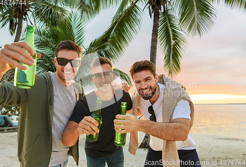 Image of young men toasting non alcoholic beer on beach