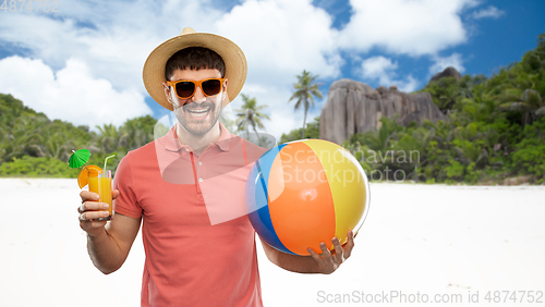 Image of happy man with orange juice and beach ball