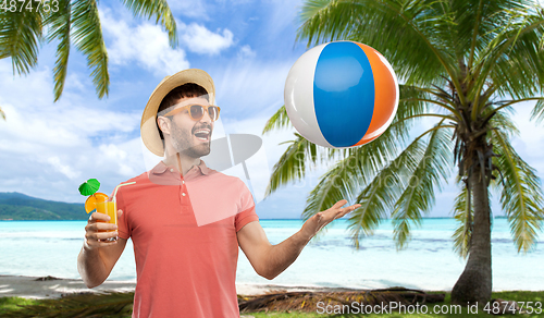 Image of happy man with orange juice and beach ball