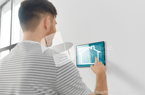 Image of man looking at tablet computer at smart home