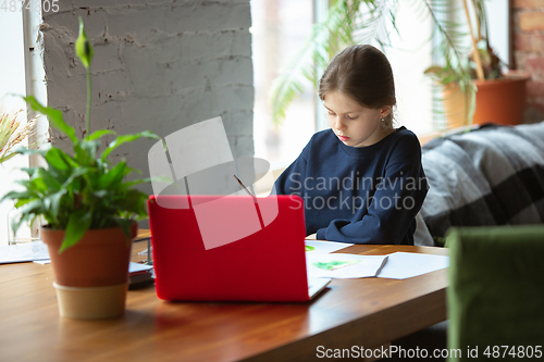 Image of Girl drawing with paints and pencils at home, watching teacher\'s tutorial on laptop. Digitalization, remote education