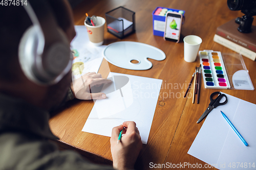 Image of Close up of man giving online drawing lessons at home. Recording teacher\'s tutorial on camera for kids. Digitalization, remote education