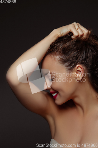 Image of Portrait of beautiful stylish woman isolated on dark studio background