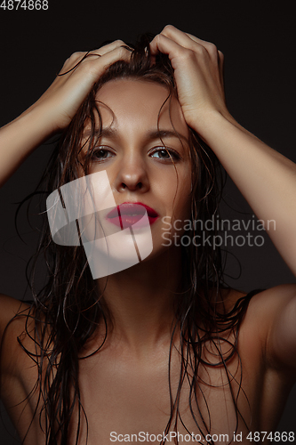 Image of Portrait of beautiful stylish woman isolated on dark studio background