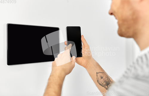 Image of man with smartphone and tablet pc at smart home