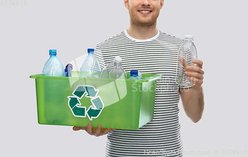 Image of smiling young man sorting plastic waste