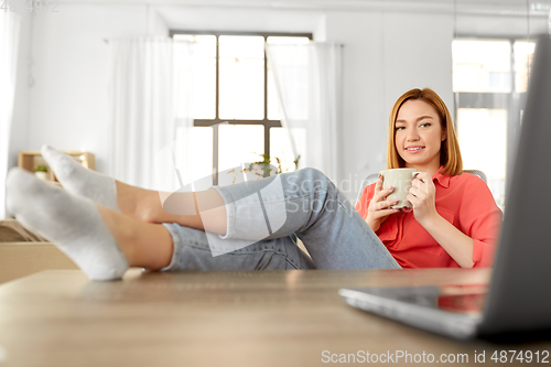 Image of woman with laptop drinking coffee at home office