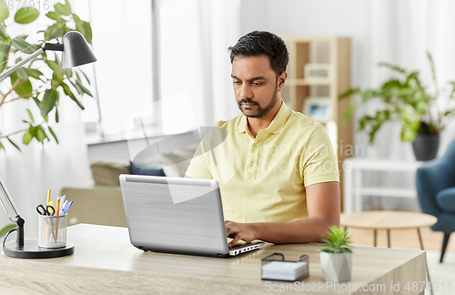 Image of indian man with laptop working at home office