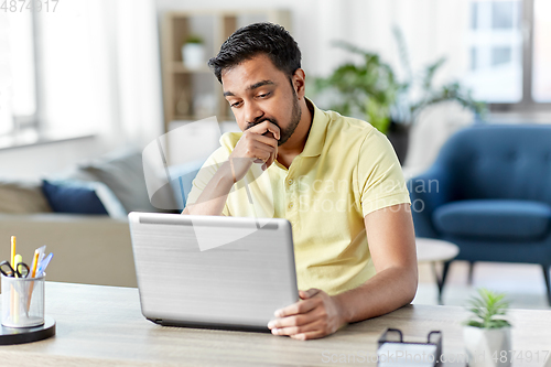 Image of indian man with laptop working at home office