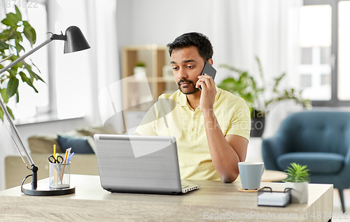 Image of man calling on smartphone at home office