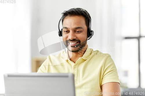 Image of indian man with headset and laptop working at home