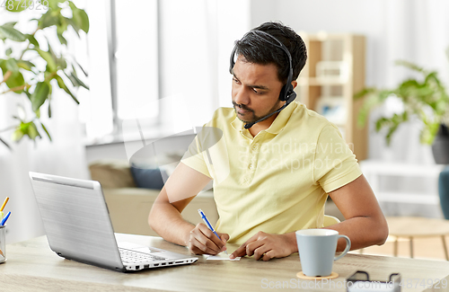Image of indian man with headset and laptop working at home