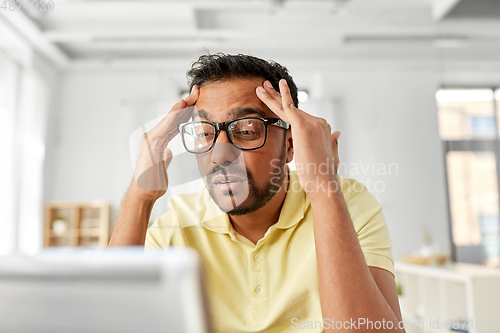 Image of stressed man with laptop working at home office