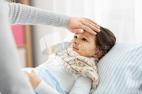 Image of mother measuring temperature of sick daughter