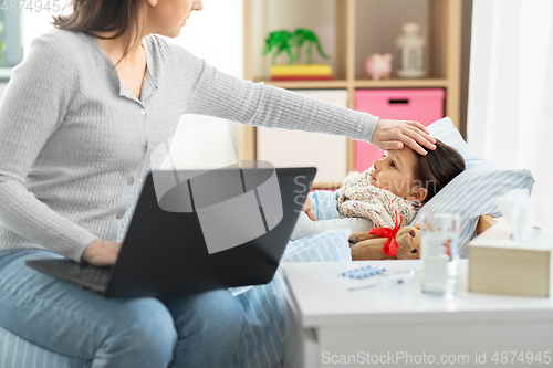 Image of ill daughter and mother with laptop at home