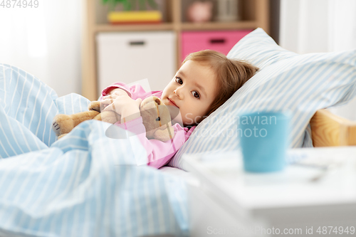 Image of sick little girl lying in bed at home