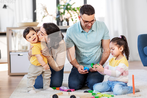 Image of happy family palying with wooden toys at home