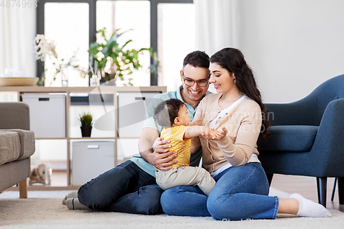 Image of happy family with child sitting on floor at home