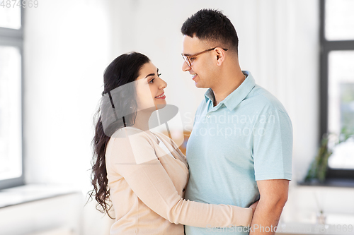 Image of happy couple hugging at home