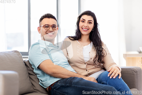 Image of happy couple sitting on sofa at home