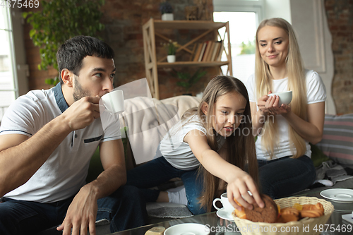 Image of Mother, father and daughter at home having fun, comfort and cozy concept