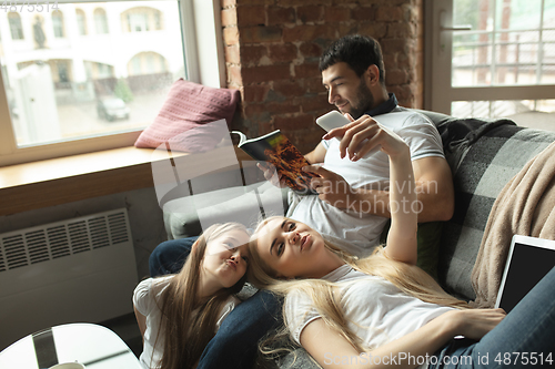 Image of Mother, father and daughter at home having fun, comfort and cozy concept