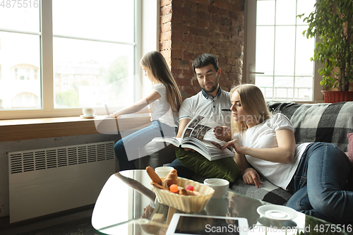 Image of Mother, father and daughter at home having fun, comfort and cozy concept