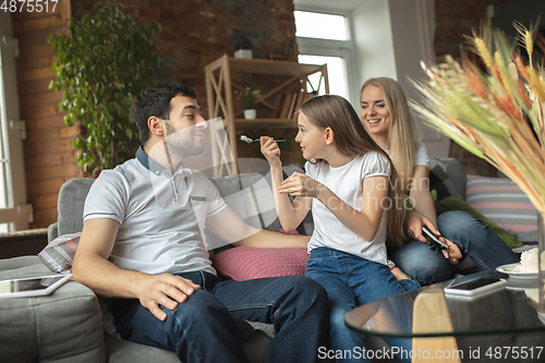 Image of Mother, father and daughter at home having fun, comfort and cozy concept