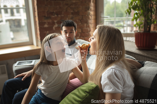 Image of Mother, father and daughter at home having fun, comfort and cozy concept