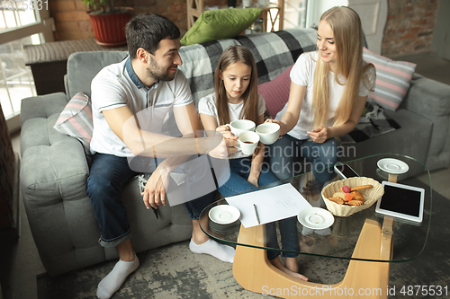 Image of Mother, father and daughter at home having fun, comfort and cozy concept