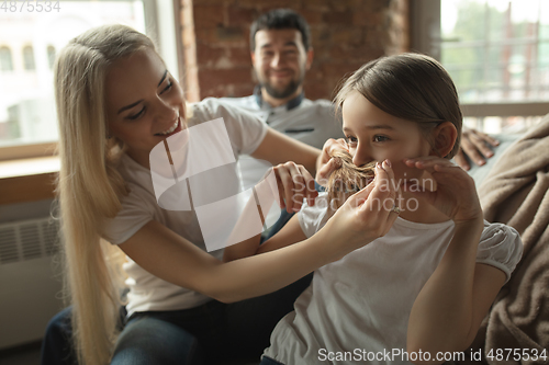 Image of Mother, father and daughter at home having fun, comfort and cozy concept