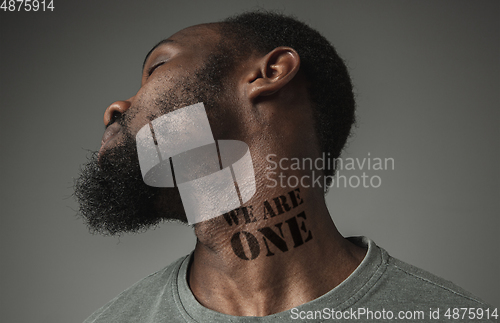 Image of Close up portrait of a black man tired of racial discrimination has tattooed slogan on his neck