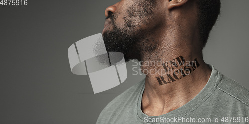 Image of Close up portrait of a black man tired of racial discrimination has tattooed slogan on his neck